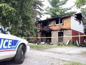 Police stand watch outside a fire at 1077 Dynes Road. It was one of two arson fires that night.