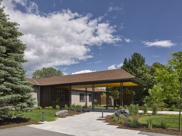 The entryway is practically unrecognizable from the original with a new extended front porch, landscaping and textured elements like wooden slacks and a jagged concrete path.