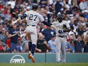 New York Yankees' Giancarlo Stanton (27) celebrates his solo home run with Adeiny Hechavarria during the seventh inning of a baseball game against the Boston Red Sox in Boston, Saturday, Sept. 29, 2018.