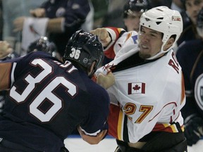 André Roy, while with the Calgary Flames in 2008, delivers a right against the Edmonton Oilers' Mathieu Roy.