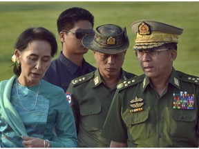 In this May 6, 2016, file photo, Aung San Suu Kyi confers with senior General Min Aung Hlaing.