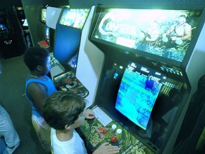 FILE- In this July 21, 1987, file photo, Carlos Tunnerman, 10, plays the "Contra" video game at an arcade in a Miami, Fla. Decades of study have failed to validate the most prevalent fear, that violent games encourage violent behavior. But from the moment the games emerged as a cultural force in the early 1980s, parents fretted about the way kids could lose themselves in games as simple and repetitive as "Pac-Man," "Asteroids" and "Space Invaders."
