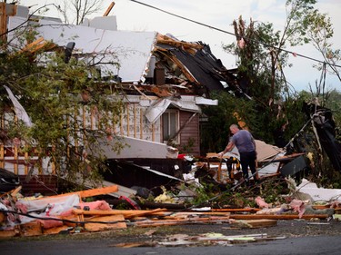 People collect personal effects from damaged homes following a tornado in Dunrobin, Ontario.