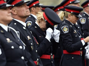 An unidentified police officer adjusts her hat before the Canadian Police and Peace Officers' Memorial Service on Sunday.