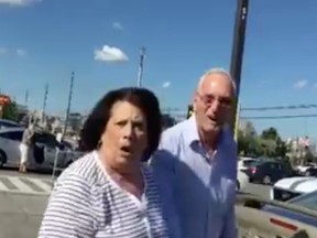 Screen capture from a Facebook video allegedly showing a couple making racist insults to a woman in a city parking lot.