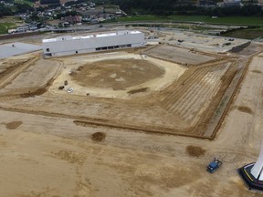 This Aug. 25, 2018, photo, shows a general view of a dismantled stadium for the opening and closing ceremonies of the 2018 Pyeongchang Winter Olympics with the Olympic cauldron, right, in Pyeongchang, South Korea. The Pyeongchang Winter Olympics closed just seven months ago. Left behind are empty venues, feuding over who pays for upkeep, and a glistening-white ski course that's now an abandoned dirt runway, strewn with rocks and unused gondolas.