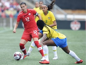 Canada's Christine Sinclair, left, protects the ball from Brazil's Ludmila, bottom, and Andressa Alves during first half soccer action in Ottawa on Sunday, Sept. 2, 2018.