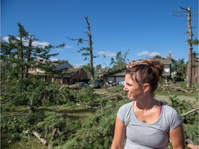 Anne Bourgeau surveys her home in Arlington Woods on Saturday morning as residents in Ottawa's west end deal with the aftermath of the twisters that touched down on Friday afternoon.