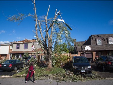 Residents survey the damage on Elvaston Ave in the Craig Henry neighbourhood on Saturday morning as residents in Ottawa's west end deal with the aftermath of the twister that touched down on Friday afternoon. Photo by Wayne Cuddington/ Postmedia