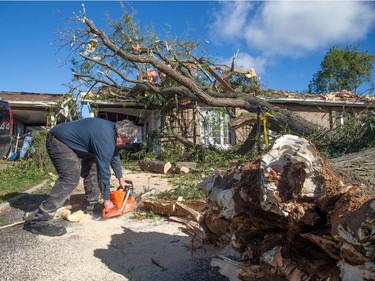 Residents begin to clear the damage on Elvaston Ave in the Craig Henry neighbourhood on Saturday morning as residents in Ottawa's west end deal with the aftermath of the twister that touched down on Friday afternoon