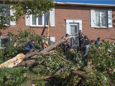 Residents begin to clear the damage on Elvaston Ave in the Craig Henry neighbourhood on Saturday morning as residents in Ottawa's west end deal with the aftermath of the twister that touched down on Friday afternoon.