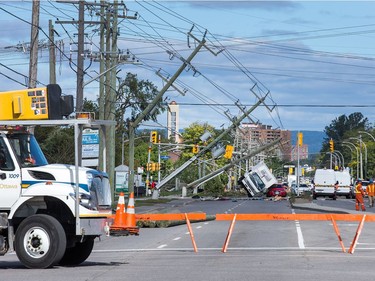 Damaged power lines and a pair of vehicles on Greenbank Rd as seen on Saturday morning as residents in Ottawa's west end deal with the aftermath of the twister that touched down on Friday afternoon.