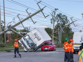 Damaged power lines and a pair of vehicles on Greenbank Rd as seen on Saturday morning as residents in Ottawa's west end deal with the aftermath of the twister that touched down on Friday afternoon.