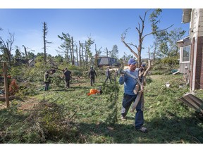 Volunteers and neighbours pitch in to remove debris from a Parkland Cr