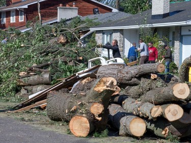 Volunteers clear debris on Parkland Cres as the region continues to deal with the after effects of the tornados that struck the region on Friday.