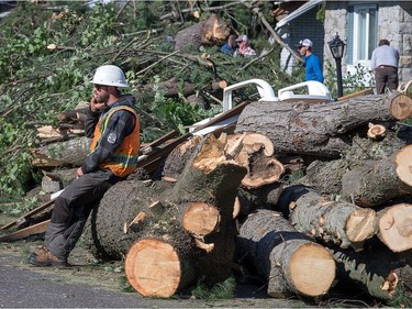 A tree service worker takes a break on Parkland Crescent as the region continues to deal with the after effects of the tornados that struck the region on Friday.