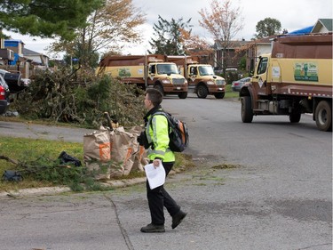 A large number of city trucks remove branches in the Craig Henry on Saturday, eight days after the area was damaged badly by a tornado. Wayne Cuddington/Postmedia