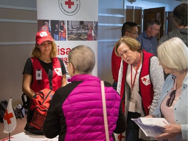 Canadian Red Cross volunteers listen to a resident at a City of Ottawa information session on Saturday. Wayne Cuddington/Postmedia