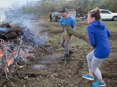 Kelly and Joseph Lafreniere organized friends to help them burn fallen trees on their property near Dunrobin on Saturday. Wayne Cuddington/Postmedia
