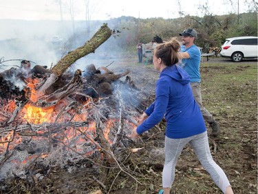 Kelly and Joseph Lafreniere organized friends to help them burn fallen trees on their property near Dunrobin on Saturday, eight days after a tornado ripped through the area. Wayne Cuddington/Postmedia