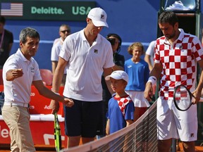 Tennis umpire Carlos Ramos, left, prepares to officiate the Davis Cup semifinal singles match between Sam Querrey, center of the United States and Marin Cilic of Croatia, in Zadar, Croatia, Sunday, Sept. 16, 2018.