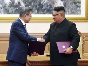 South Korean President Moon Jae-in, left, and North Korean leader Kim Jong Un shakes hands after signing the documents at the Paekhwawon State Guesthouse in Pyongyang, North Korea, Wednesday, Sept. 19, 2018. Moon and Kim announced a sweeping set of agreements after their second day of talks in Pyongyang on Wednesday that included a promise by Kim to permanently dismantle the North's main nuclear complex if the United States takes corresponding measures, the acceptance of international inspectors to monitor the closing of a key missile test site and launch pad and a vow to work together to host the Summer Olympics in 2032. (Pyongyang Press Corps Pool via AP)