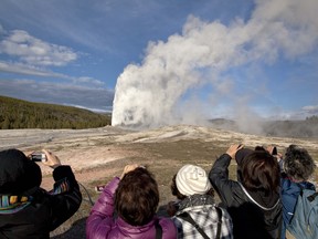 FILE - In this May 21, 2011, file photo, tourists photograph Old Faithful erupting on schedule late in the afternoon in Yellowstone National Park, Wyo. A thermal spring near Old Faithful in Yellowstone National Park has erupted for the fourth time in the last 60 years, a park official said Thursday, Sept. 20, 2018. (AP Photo/Julie Jacobson, File) ORG XMIT: PDX412