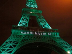 FILE - In this file photo dated Friday Nov.4, 2016, the Eiffel Tower lit up in green to mark the success of the Paris Agreement to slash man-made emissions of carbon dioxide and other global warming gases to counter climate change, in Paris. Inscription reads, "it's done".