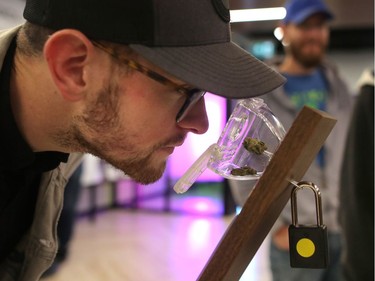 Cole Hendry, 25, smells cannabis at Nova Cannabis on opening day in Calgary, on Wednesday October 17, 2018.