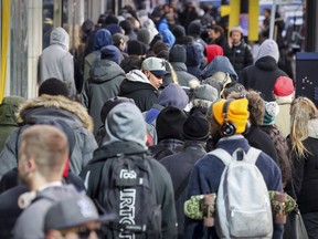 People wait to get into the downtown Société québécoise du cannabis in Montreal on Thursday, Oct. 18, 2018, one day after the recreational use of cannabis became legal in Canada.