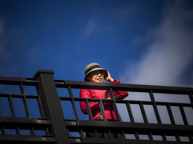 A woman stand on the Mackenzie King Bridge watching the process take place Saturday.