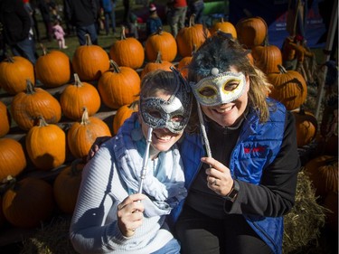 Jamie Gutzman, left, and Susan Chell from RE/MAX, donated the pumpkins for the Civic Hospital Neighbourhood Association's Pumpkins in the Park event on Saturday.   Ashley Fraser/Postmedia