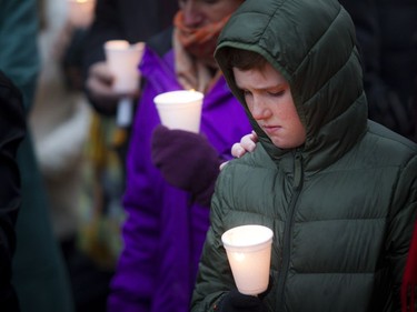 A young boy holds a candle at the Canadian Human Rights monument Sunday October 28, 2018, during a solidarity vigil against anti-semitism and white supremacy.   Ashley Fraser/Postmedia