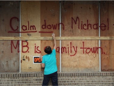 MEXICO BEACH, FL - OCTOBER 09: Carol Cathey spray paints the words "Calm down Michael" on the plywood over her daughter's business in preparation for the arrival of Hurricane Michael on October 9, 2018 in Mexico Beach, Florida. The hurricane is forecast to hit the Florida Panhandle at a possible category 3 storm.