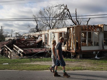 PANAMA CITY, FL - OCTOBER 11:  People walk past a home destroyed by Hurricane Michael on October 11, 2018 in Panama City, Florida. The hurricane hit the Florida Panhandle as a category 4 storm.
