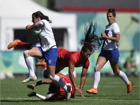 Lucy Hapulat of France, left, evades a tackle by Olivia de Couvreur of Ottawa during Canada's Women Rugby Sevens match at the Buenos Aires 2018 Youth Olympic Games on Monday.