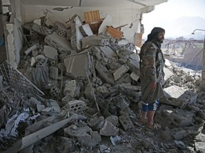 A man inspects the rubble of a Houthi-held detention center destroyed by Saudi-led airstrikes in Sanaa, Yemen, Wednesday, Dec. 13, 2017.