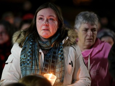 A cousin of Émilie Maheu looks skyward with tears rolling down her face as Amazing Grace is played at a vigil for the young woman Wednesday evening (Oct. 24, 2018) in Alexandria.