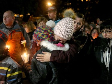 Some of Émilie Maheu's family members (front) hug following a vigil held for the young woman Wednesday evening (Oct. 24, 2018) in Alexandria.