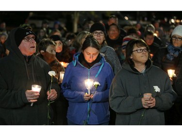 Mourners listen to speakers while holding candles at a vigil held in the memory of Émilie Maheu on Wednesday evening (Oct. 24, 2018) in Alexandria.