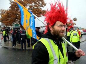 About 30 protesters braved the pouring rain to march outside the Canada Post building at the corner of Riverside Drive and Industrial Avenue in Ottawa Wednesday as the 24-hour rotating strike hits Ottawa today.