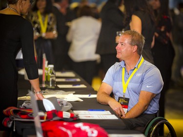 Paralympian Todd Nicholson chats with a volunteer looking after the silent auction table.