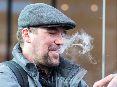 A man smokes marijuana while speaking to the media outside of a cannabis store in Montreal, Quebec on October 17, 2018. -