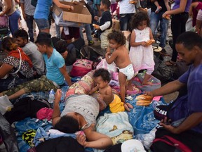 Honduran migrants taking part in a caravan heading to the US, rest at the main square in Tapachula, Chiapas state, Mexico, on October 21, 2018. - Thousands of Honduran migrants resumed their march toward the United States on Sunday from the southern Mexican city of Ciudad Hidalgo, AFP journalists at the scene said.