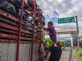 Honduran migrants board a truck in Mexico as they take part in a caravan heading to the U.S.