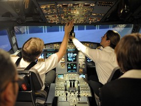 Air Canada Captain Rod Graham, left, and first officer Christine Lyon, right, run though a demonstration of simulator training near Pearson Airport in Toronto, in December 2012.