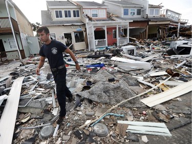 Firefighter Austin Schlarb performs a door to door search in the aftermath of Hurricane Michael in Mexico Beach, Fla., Thursday, Oct. 11, 2018.