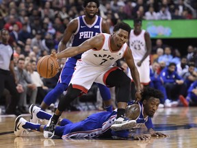 Raptors guard Kyle Lowry (7) steps over Philadelphia 76ers forward Robert Covington (33) as they battle during second half last night. (THE CANADIAN PRESS/Nathan Denette) ORG XMIT: NSD218
