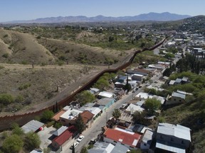 This April 2, 2017 file photo taken with a drone shows the U.S. Mexico border fence as it cuts through the two downtowns of Nogales, Ariz.
