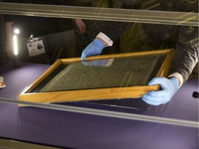 FILE - In this file photo dated Thursday, Feb. 5, 2015, The Salisbury Cathedral 1215 copy of the Magna Carta is installed in a glass display cabinet marking the 800th anniversary of the sealing of Magna Carta at Runnymede in 1215, in Salisbury, England.  British police said Friday Oct. 26, 2018, that cathedral alarms sounded Thursday afternoon when a person tried to smash the glass display box surrounding the Magna Carta in Salisbury Cathedral, and a man has been arrested.